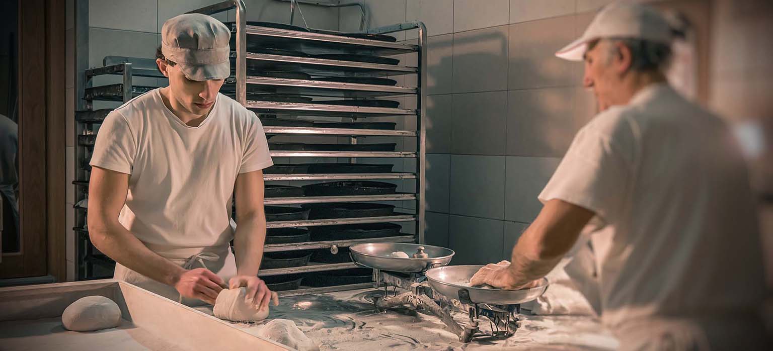 Formatura manuale del pane artigianale nel laboratorio del Panificio Perrone