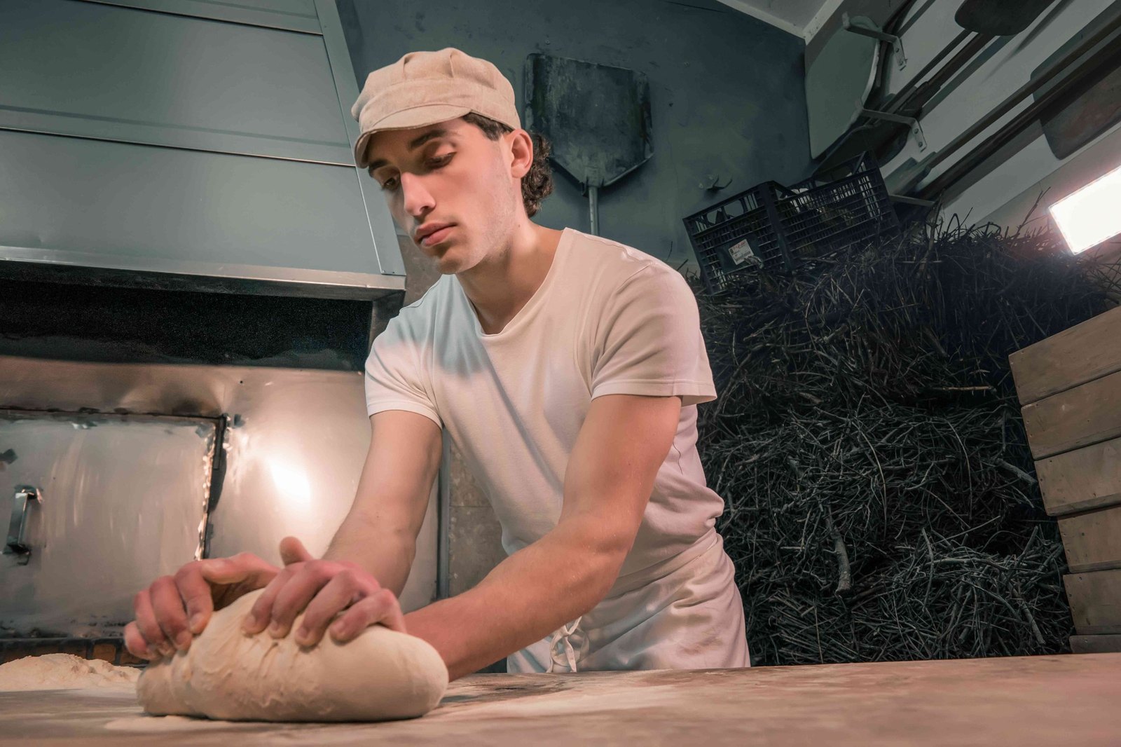 Fornaio che lavora l’impasto del pane nel laboratorio del Panificio Perrone